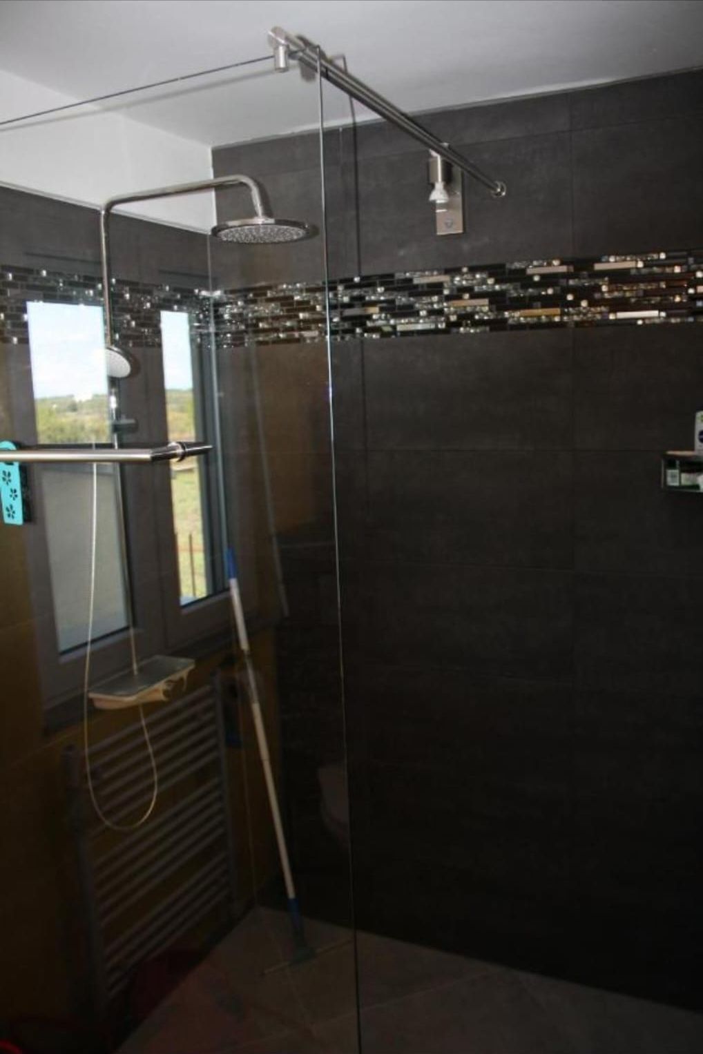 Walk-in-Regendusche mit Mosaikband und Fenster