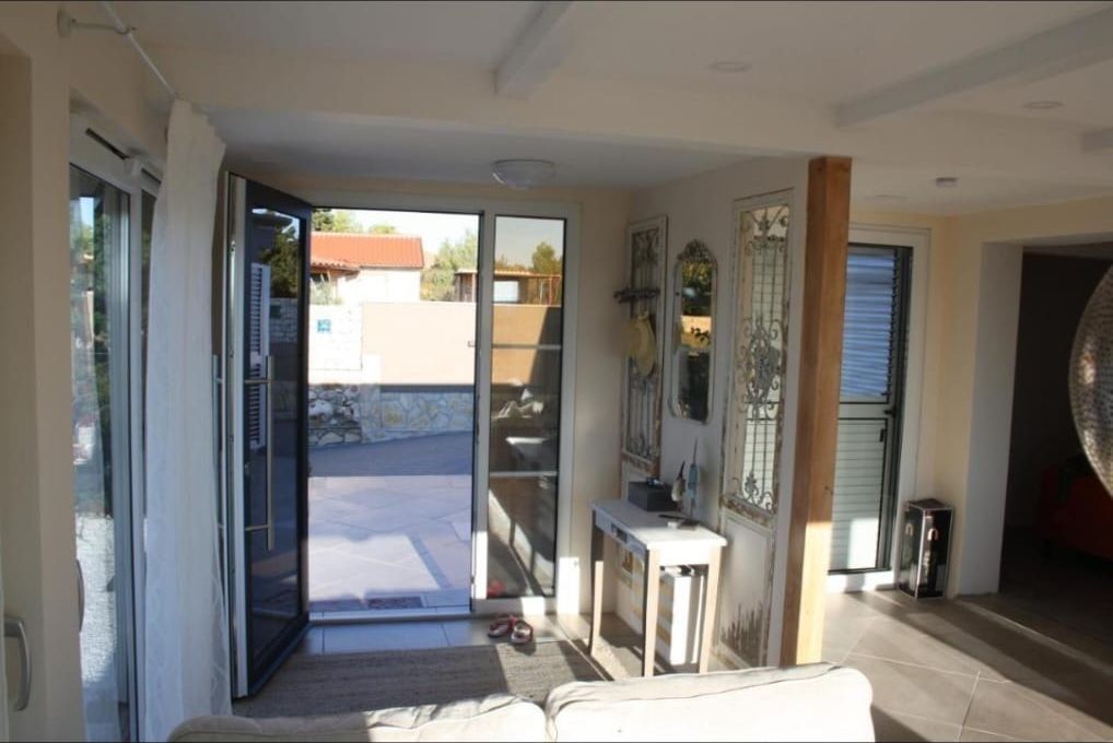 Sonniger Eingangsbereich mit Glastür zur Terrasse
