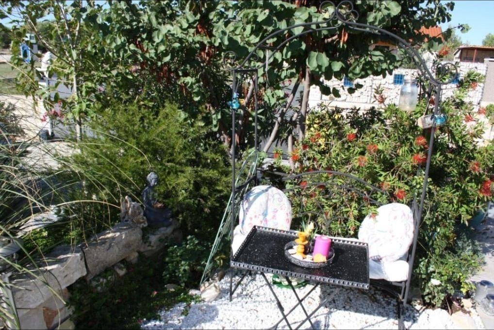 Romantische Sitzecke unter dem Rankbogen im Garten