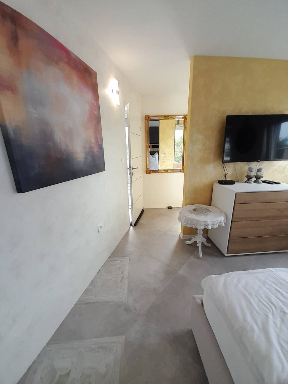 Schlafzimmer mit Wandbild und TV