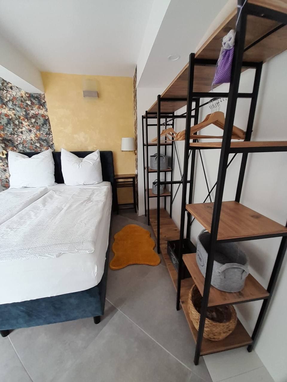 Schlafzimmer mit Doppelbett und offenem Regal